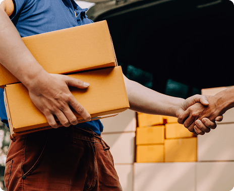 Two people shaking hands, one holding packages